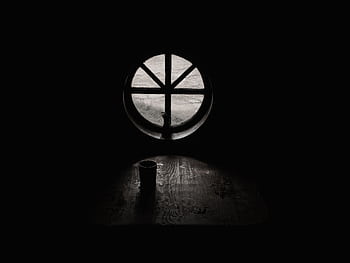 A dark, atmospheric of a cup silhouetted against a round window casting light on a wooden table. HD wallpaper