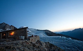 stone alpine cabin at dusk, lights, snow, sky, mountains, cabin, stones HD wallpaper