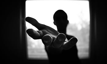 Silhouette of a hand reaching out in a black and white contrast. HD wallpaper