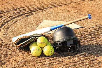 Close-up of baseball and softball gear on a dirt field, ready for a game. HD wallpaper