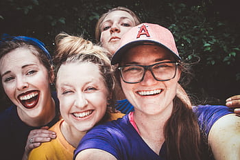 A joyful group of women taking a selfie outdoors, showcasing happiness and friendship. HD wallpaper