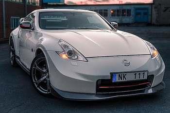 A white Nissan 370Z sports car parked in an urban setting in Norrtälje, Sweden. HD wallpaper