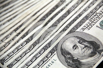 Detailed showing a close-up of neatly stacked US dollar bills, ideal for financial and economic themes. HD wallpaper