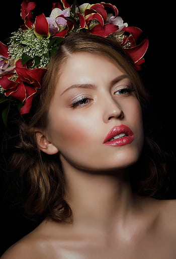 Close-up portrait of a woman with a bold floral crown on a dark background. HD phone wallpaper