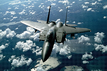 A stunning aerial view of a military fighter jet flying high above the clouds. HD wallpaper