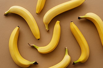 Top view of ripe bananas arranged on a brown background, perfect for healthy eating concepts. HD wallpaper