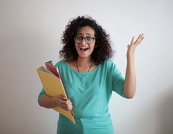 Frustrated young businesswoman holding papers, expressing stress and confusion indoors. HD wallpaper