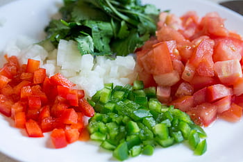Colorful diced vegetables on a plate, perfect for healthy cooking and meal prep. HD wallpaper