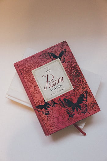 Red journal with floral and butterfly cover design against a soft background. HD phone wallpaper