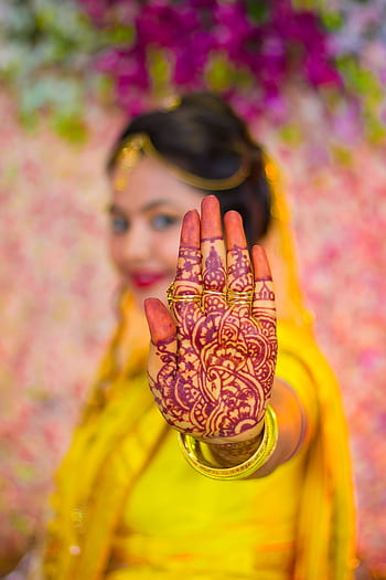 Vibrant portrait of an Indian woman showcasing intricate mehndi design on her hand, colorful background. HD phone wallpaper