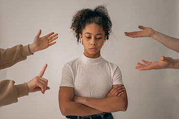 A teenage girl looks upset while expressive hands point and gesture around her. HD wallpaper