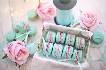 A delightful display of pastel macarons with pink roses and teal ribbons. HD wallpaper