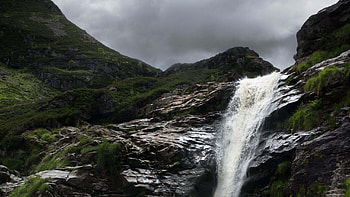 Waterfall From Rock Algae Covered Stones Mountain In White Black Clouds Sky Background Nature HD wallpaper