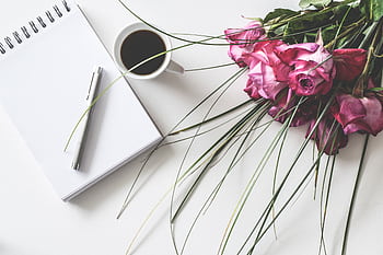 A stylish composition of pink roses, a cup of coffee, and a notepad. Perfect for romantic themes. HD wallpaper