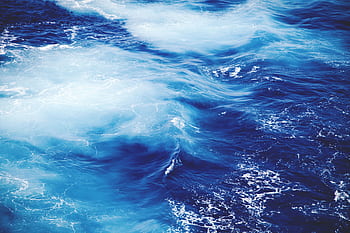 Dynamic and vibrant view of ocean waves, showcasing the deep blue and white froth of the sea. HD wallpaper