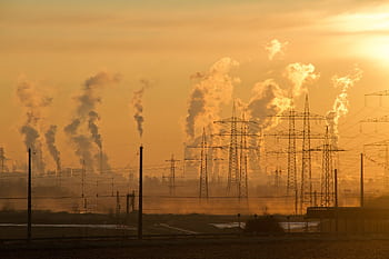 Silhouette of power lines and industrial smoke at sunset, highlighting pollution and energy themes. HD wallpaper
