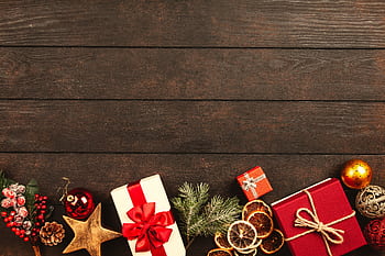 Festive Christmas gifts and decorations on rustic wood background perfect for holiday themes. HD wallpaper