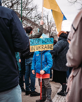 A child holds a 'Stop War in Ukraine' sign during a peaceful protest outdoors in Berlin, Germany. HD phone wallpaper