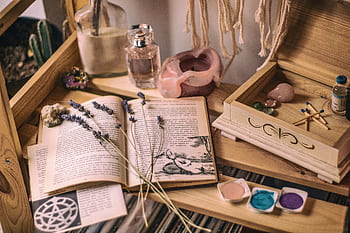 Aesthetic setup with books, lavender, crystals, and candles on a wooden shelf. HD wallpaper
