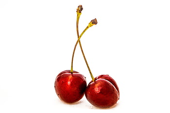 Close-up shot of two ripe red cherries with water droplets on a white background. HD wallpaper