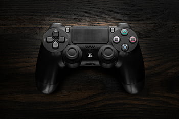 High-resolution of a Sony DualShock 4 game controller against a dark wooden background. HD wallpaper