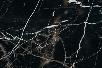 Close-up view of a black marble texture, showcasing intricate white veining patterns. HD wallpaper