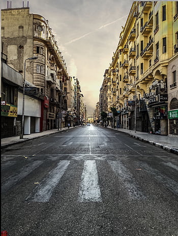 A deserted urban street surrounded by classic buildings under a warm sky. HD phone wallpaper