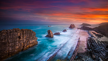 Rocks of Playa De Portio Beach, blue, sea, graphy, rocks, beach, twilight, waves, red, playa de portio, , nature, water, sunset HD wallpaper