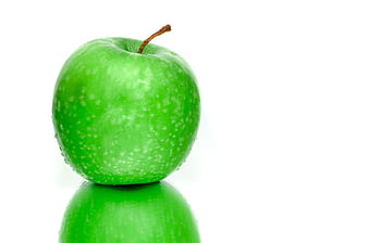 Vibrant green apple with water droplets on a reflective surface. Perfect freshness symbol. HD wallpaper