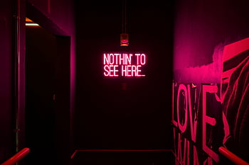Neon sign reading 'Nothin' to see here...' in an artistic dark room. HD wallpaper