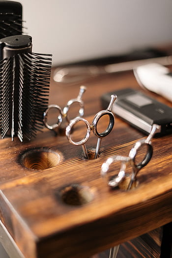 Close-up of professional hairdressing equipment on a wooden salon table, ready for use. HD phone wallpaper