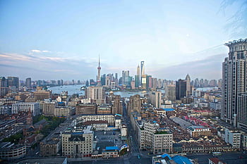 A breathtaking view of Shanghai's skyline featuring iconic skyscrapers and the Huangpu River. HD wallpaper