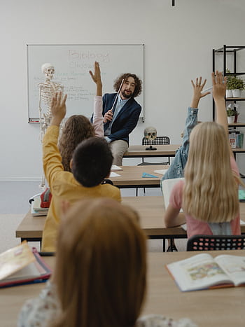A classroom with a teacher and students actively participating in a lesson about biology. HD phone wallpaper