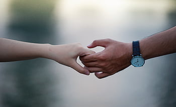 A close-up of two hands holding gently, symbolizing connection and unity. HD wallpaper