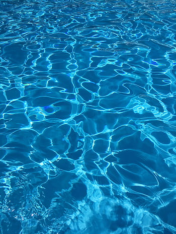 Vibrant blue swimming pool water with dynamic reflections, ideal for abstract backgrounds. HD phone wallpaper
