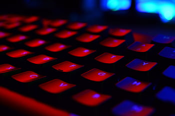 Close-up of a red backlit keyboard, highlighting the vibrant glowing keys. HD wallpaper