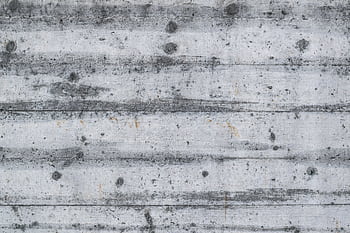 Detailed view of a gray textured concrete wall with wood patterns and imperfections. HD wallpaper
