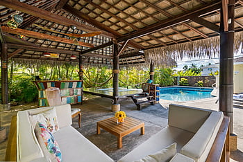 Tropical outdoor patio featuring a cabana, seating area, and swimming pool, perfect for luxury relaxation. HD wallpaper