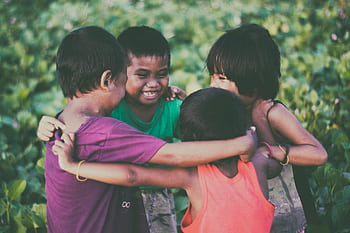 Group of children hugging and playing joyfully in Donsol, Bicol, Philippines outdoors. HD wallpaper