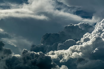A powerful depiction of dark, dramatic clouds covering the sky, showcasing the majestic beauty of nature. HD wallpaper