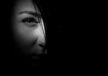 Mysterious black and white portrait of a woman's face in dramatic lighting. HD wallpaper