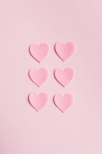 Soft pink heart shapes on a light pink background, perfect for romantic themes. HD phone wallpaper