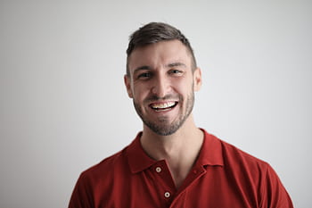 A cheerful man smiling broadly against a plain white background. HD wallpaper