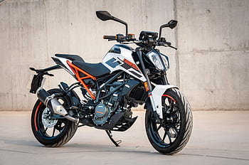 A modern sports motorcycle parked in an industrial setting, showcasing its design. HD wallpaper