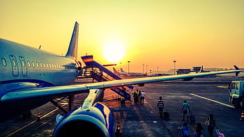 A vibrant of passengers boarding an airplane at sunrise, highlighting air travel. HD wallpaper